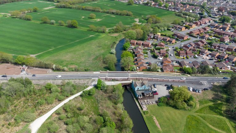 Aerial shot of York's Bridge showing the canal, pub, housing estate and countryside.