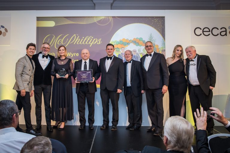 A group of people stood together in a line accepting an award.